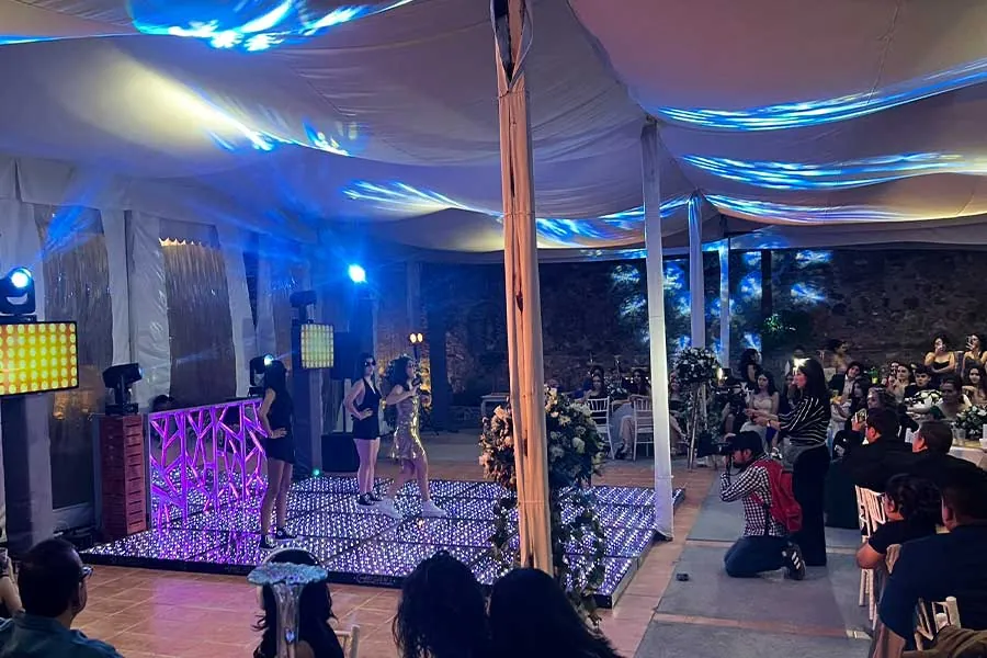 Show en vivo en evento social con piso LED y cantante en escenario